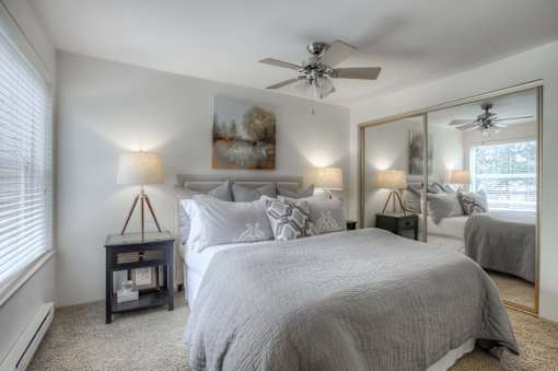 A bedroom with a large bed and a ceiling fan.