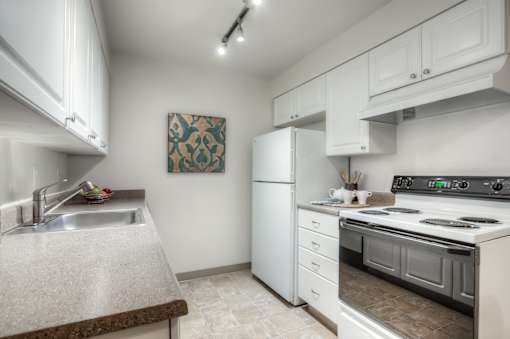 A kitchen with white appliances and cabinets.