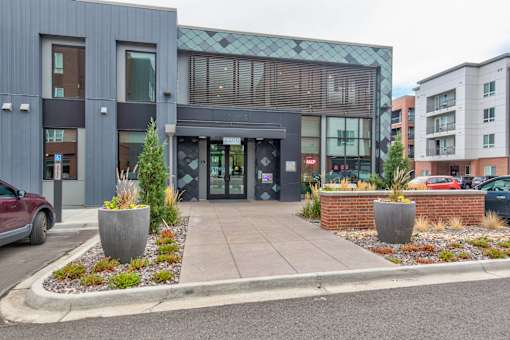 the front of a building with a sidewalk and planters