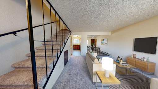 a living room with a staircase and a tv