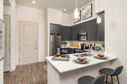 a kitchen with a large island and a stainless steel refrigerator