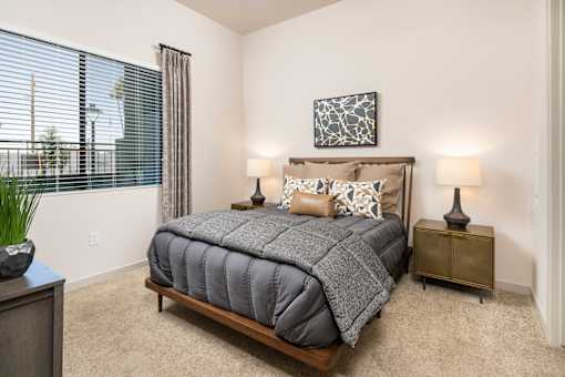 a bedroom with a bed and a window with blinds