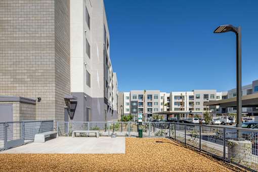 a large building with a sidewalk and a fence in front of it