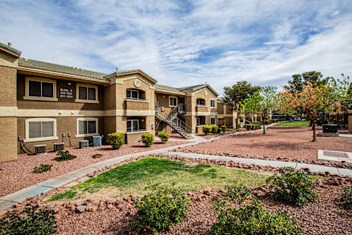 A building with a brown facade and a green lawn in front.