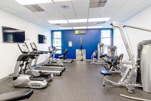 a gym with various exercise equipment and a tv