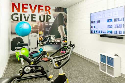 a workout room with weights and a motivational poster on the wall