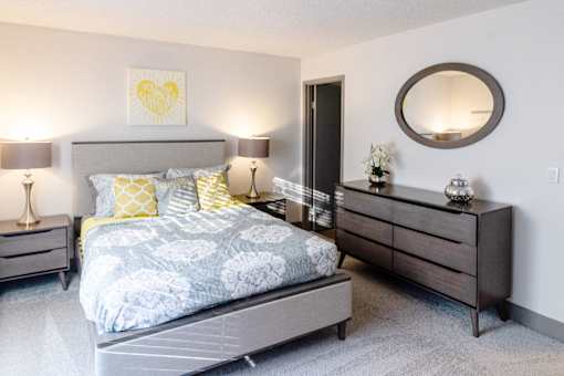 a bedroom with a bed and dresser and a mirror
