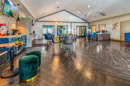 a clubhouse with a dining area and a kitchen with a table and chairs