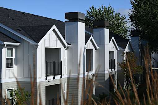 A row of houses with white siding and black accents.