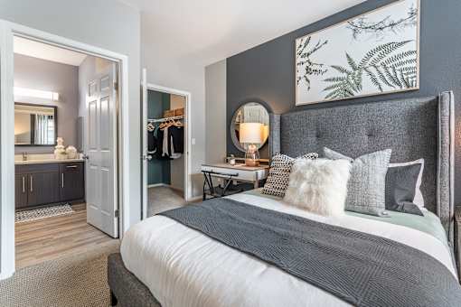 a bedroom with a large bed and a door to a bathroom