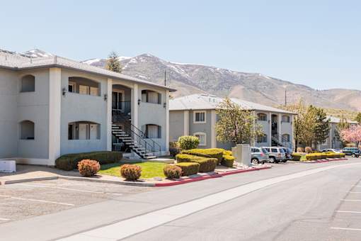 a row of apartment buildings with mountains in the background