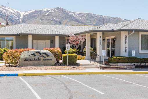 a building with mountains in the background in a parking lot