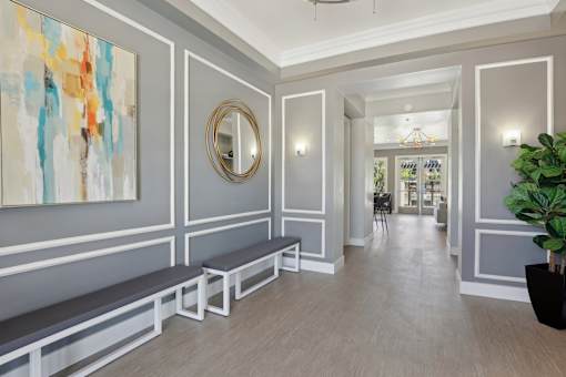 a long hallway with benches and a painting on the wall