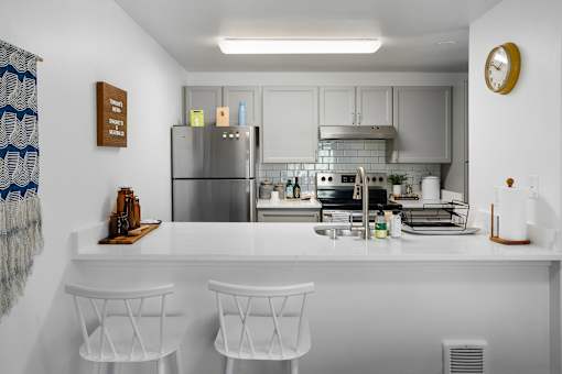 A kitchen with a white countertop and stainless steel appliances.