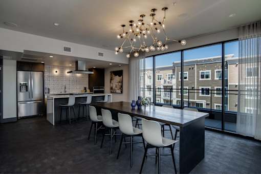 a kitchen with a large island with chairs and a large window