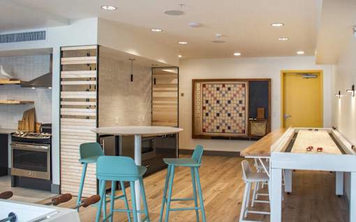 a kitchen with a bar and a table with blue stools