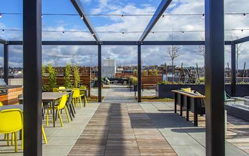 the roof terrace with tables and chairs and a view of the city