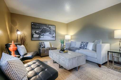 A living room with a black leather chair and a white couch.