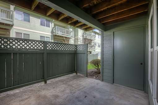 A balcony with a lattice fence and a green door.