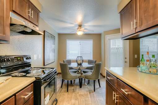 A kitchen with a dining table and chairs.
