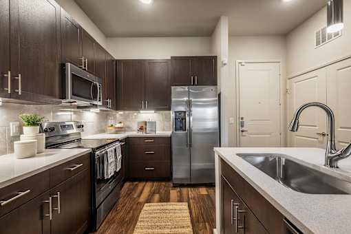 A kitchen with dark wood cabinets and stainless steel appliances.