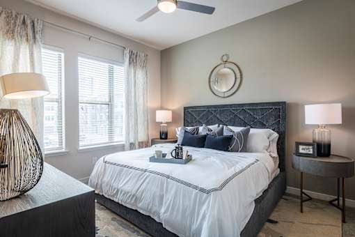 A bedroom with a large bed and a ceiling fan.