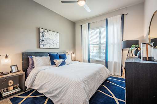 A bedroom with a large bed and a ceiling fan.