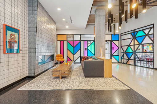 the lobby of a building with a colorful stained glass wall and a couch