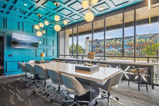 a conference room with blue walls and a large table and chairs