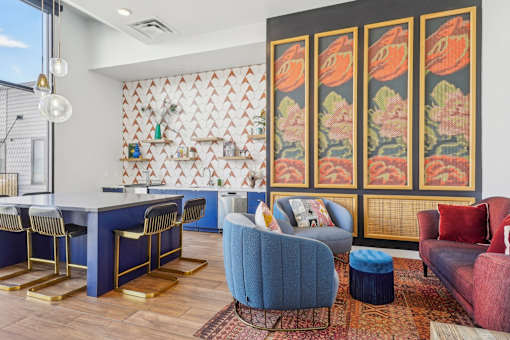 a view of a room with a wall filled with colorful quilts and chairs