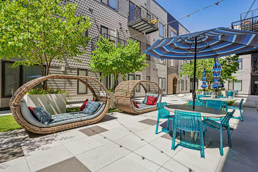 a patio with chairs and tables and umbrellas