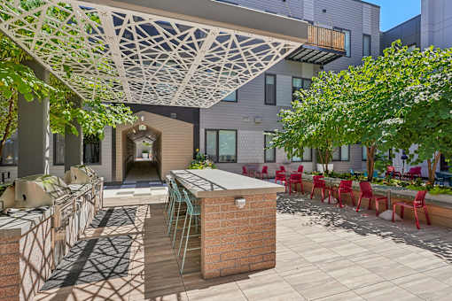 a patio with a bar and chairs and a building