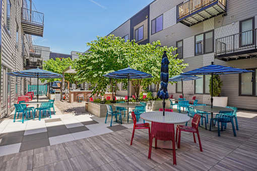 a patio with tables and chairs and umbrellas