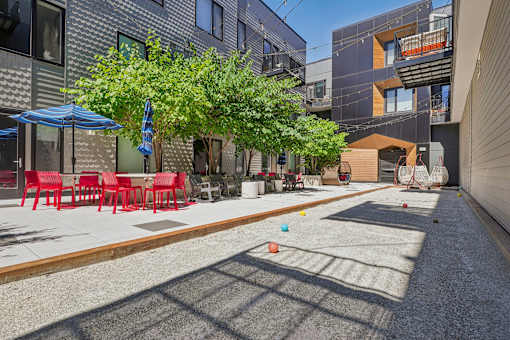 a patio with tables and chairs and trees