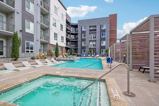 a swimming pool with an apartment building in the background