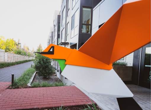 an orange and white sculpture in front of a building