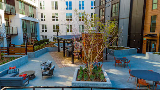 a courtyard with a table and chairs in front of a building