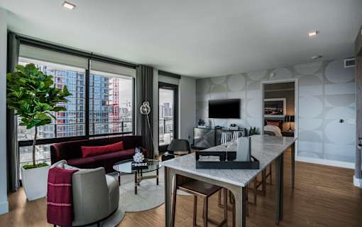 a living room and dining room with a table and chairs