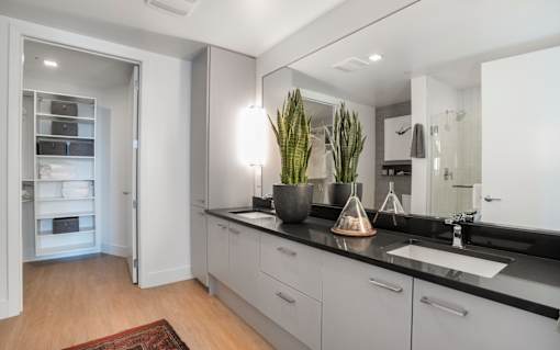a white and black kitchen with a sink and a mirror