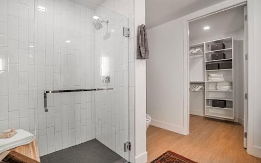 a white bathroom with a shower and a closet