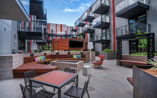 a courtyard with tables and chairs and a fire pit
