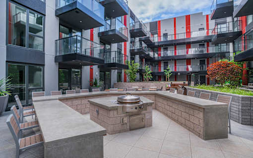 an outdoor patio with a fire pit in front of an apartment building