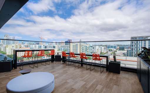 a view of a city from a balcony with chairs and a table