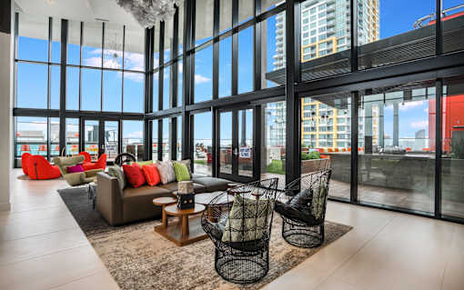 couch and chairs in front of ceiling high windows