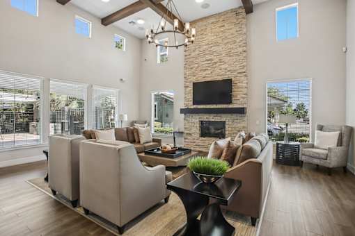 A modern living room with a stone fireplace and a large window.