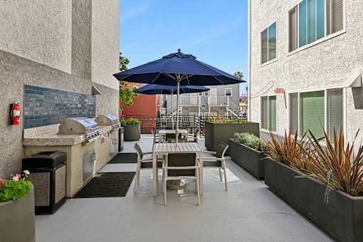 A patio with a table and chairs under an umbrella.