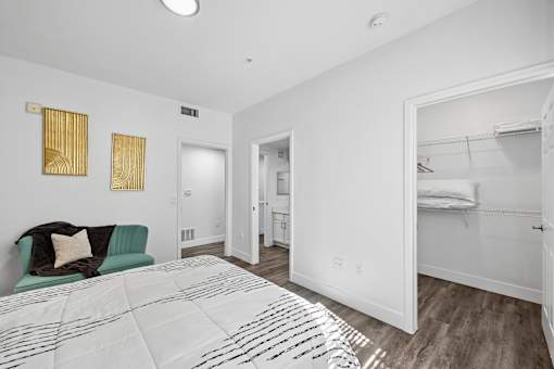 A bedroom with a bed, a couch, and a closet.