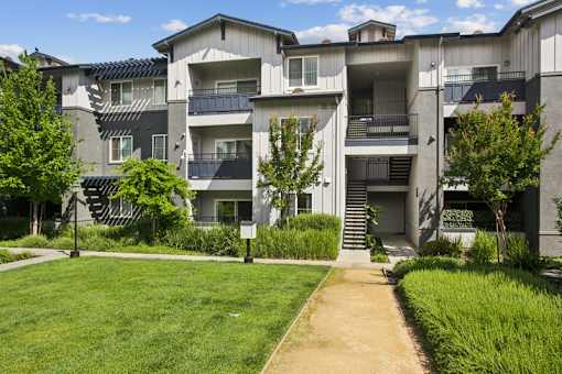 Apartment complex with a green lawn in front.