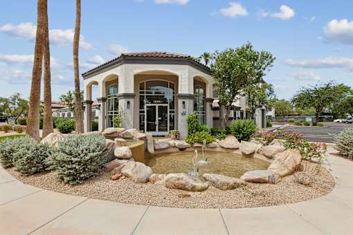 A house with a fountain in front of it.
