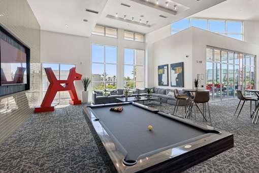 A pool table in a room with a large window and a view of the outside.